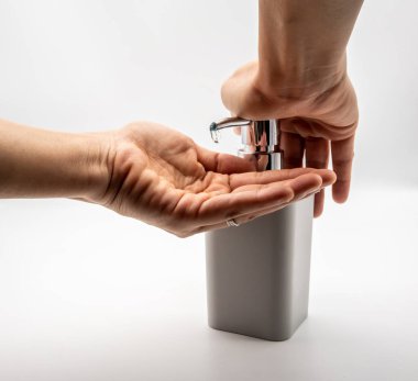 Beyaz arka planda el dezenfektanı olarak alkol jeli kullanılıyor..