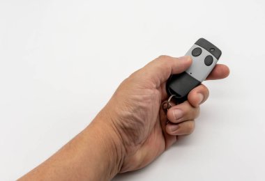 Beyaz arkaplanda siyah ve gri renkli uzaktan kumandalı ev kapısı var.