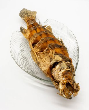 Beyaz arka planda izole edilmiş balık tabağında kızarmış balık..