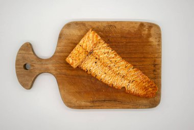 Baharatlı kuru ve yuvarlanmış mürekkep balığı beyaz arka planda izole edilmiş tahta kesme tahtasının üzerinde. Acı biber baharatlı deniz ürünleri..