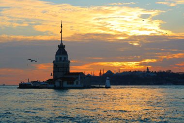 Kızların Kulesi, namı diğer Kiz Kulesi, gün batımında. Arka planda İstanbul şehri manzarası var. İstanbul arka plan fotoğrafı. İstanbul 'a seyahat. 