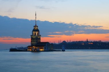 Kızların Kulesi, namı diğer Kiz Kulesi, gün batımında. Arka planda İstanbul şehri manzarası var. İstanbul arka plan fotoğrafı. İstanbul 'a seyahat. 