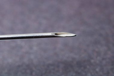 Gri arkaplanda bir şırınganın makro fotoğrafı