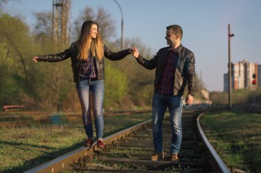 Bir erkek ve bir kadın el tutulur ve demiryolu ile gitmek.
