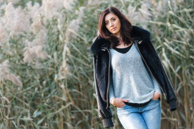 Sazlık bir arka plan üzerinde güzel bir esmer portresi.