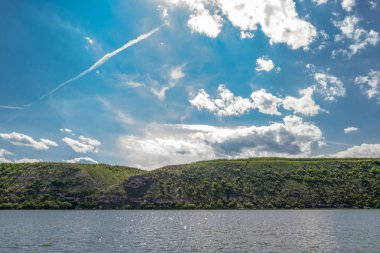 Bir tepe ve mavi gökyüzü ile bir nehir manzara.