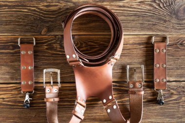 Kahverengi çift kamera koşum, çoklu kamera askısı emniyet kemeri, deri kahverengi ahşap zemin üzerinde boyun askısı.