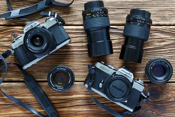 Kişinev, Moldovya - Jule 06, 2017: iki vintage film kameraları Minolta Xd 7 ve Minolta X-300 ve lensler ahşap arka planda Kişinev, Moldovya.