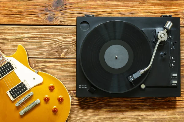 E-Gitarre und Plattenspieler mit Vinyl auf Holzgrund. — Stockfoto