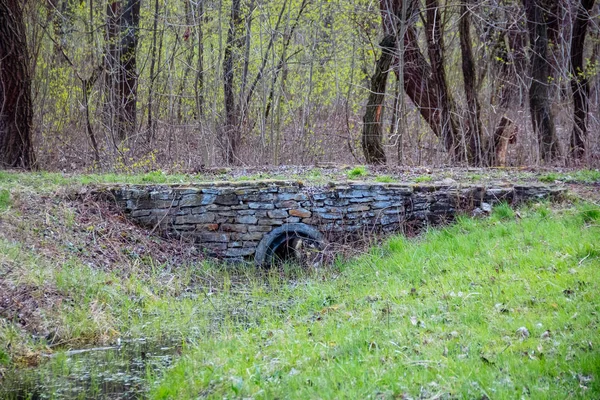 Un puente de piedra sobre un pequeño río . — Foto de Stock