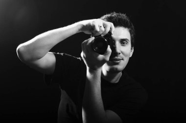 Siyah arka plan üzerine film kamera ile fotoğrafçı.