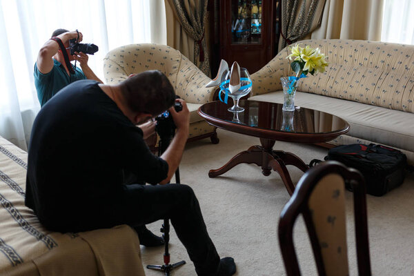 Preparation for wedding. Professional cameraman and photographer shooting shoes and flowers bride.