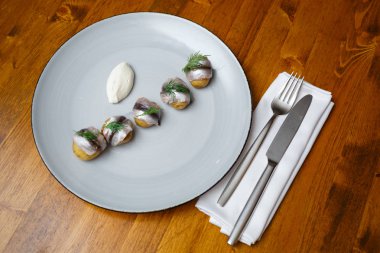 Beyaz plaka üzerinde genç patates ile ringa balığı. Ahşap arka plan. Yatay olarak çerçeveli atış.