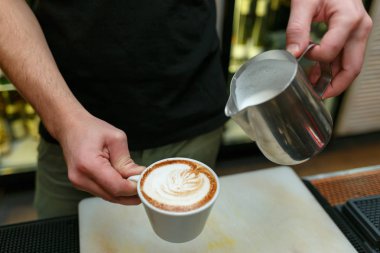 Profesyonel barista kahve yapmak için süt dökme. Sığ derinlik-in tarla.