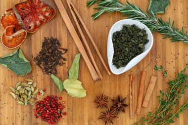 Çin Çin çayı yeşil çay kravat Guan Yin beyaz bir kase kuru. Bir sürü çay için malzemeler ahşap bir gemide dağınık.