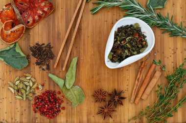 Çin Oolong kuru çay beyaz bir kase içinde karıştırın. Bir sürü çay için malzemeler ahşap bir gemide dağınık.