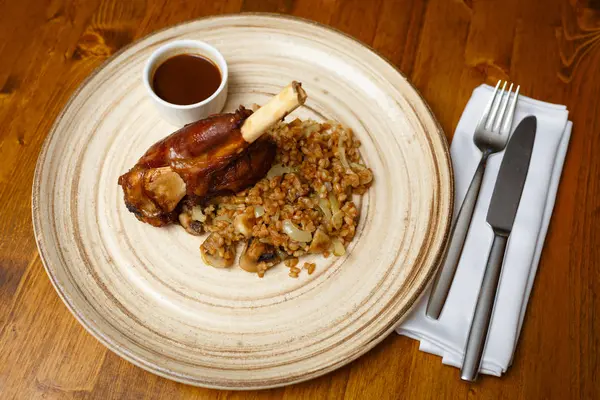 Kuzu yan yemekler ve bej plaka üzerinde sos ile kemik üzerinde. Ahşap arka plan.