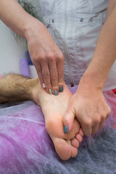 Massaggio ai piedi. Fisioterapista massaggiatore che fa un massaggio alle gambe a un uomo in clinica. Da vicino. . — Foto Stock