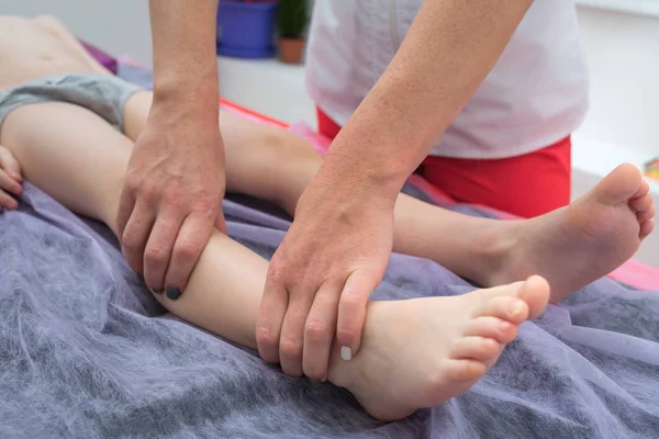 Voetmassage. Masseuse fysiotherapeut geven been massage met een jongen in kliniek. — Stockfoto