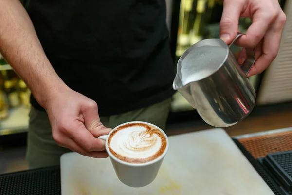 Profesjonalnych barista wlewając mleko do kawy. Płytkiej głębi ostrości. — Zdjęcie stockowe