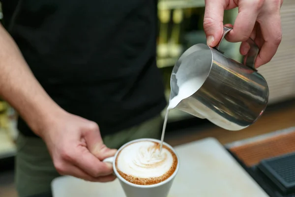 Profesjonalnych barista wlewając mleko do kawy. Płytkiej głębi ostrości. — Zdjęcie stockowe