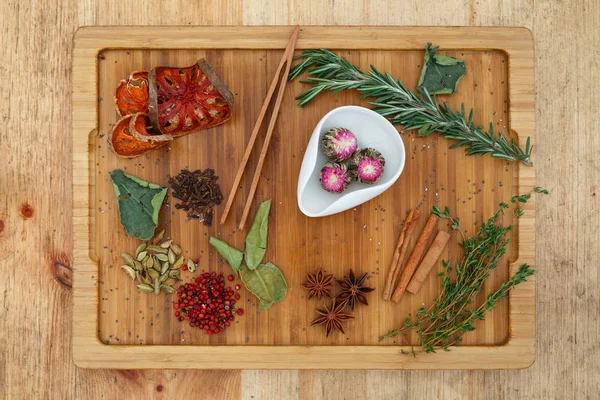 Chá de jasmim chinês Oolong Moli Yu Lun Tao em uma tigela branca. Em uma placa de madeira espalhou um monte de ingredientes para o chá . — Fotografia de Stock