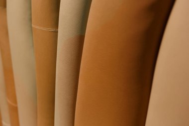 Deri, dikişli, dalgalı doku. Kahverengi ve bej.