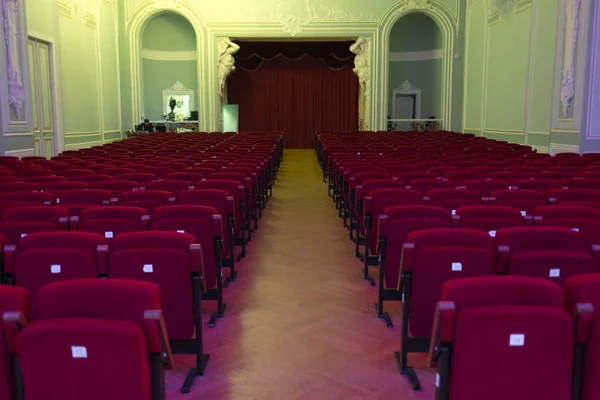 Asientos rojos con números y pasillo central en cine, teatro, sala de conciertos . —  Fotos de Stock