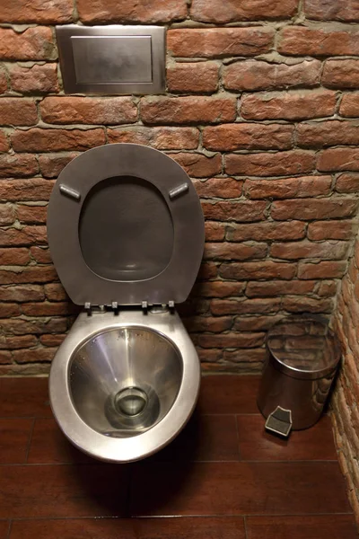 Rostfria WC-skål på tegel vägg bakgrund. — Stockfoto