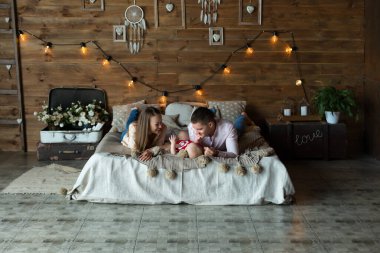 Ebeveynler ve çocukları yatakta yatıyor. Anne, baba ve bebek. Genç bir ailenin portresi. Mutlu aile hayatı. İnsanoğlu doğdu.