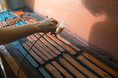 Deri ustası kayışlar üzerinde boya neden olur. Kahverengi boyalı sprey tabanca. El yapımı konsept. Deri ürünleri oluşturmak için küçük işletme kavramı.