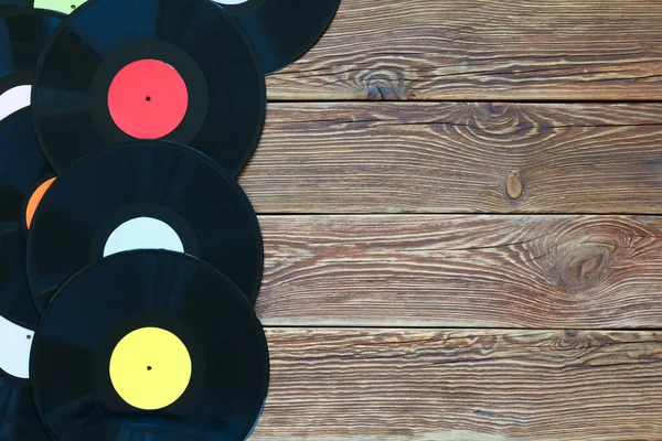 Retro-Schallplatten auf Holztischhintergrund. Bunte Etiketten. Ansicht von oben. Platz zum Kopieren von Raum. — Stockfoto