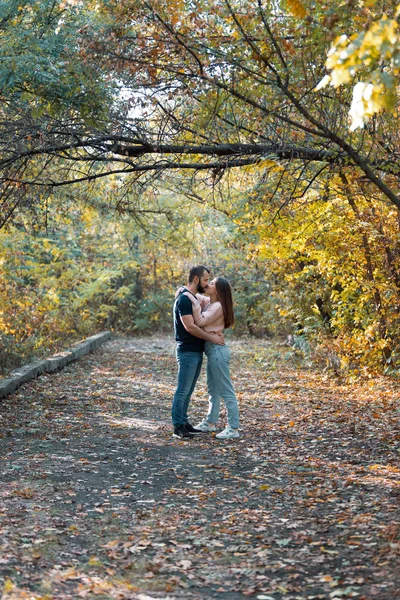 Junges verliebtes Paar, das sich im Park umarmt und küsst. Mann und Frau allein miteinander. warmer Herbstabend im Wald. — Stockfoto