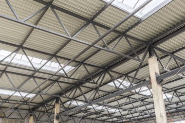 Metal çerçeveli alüminyum çatı. Yapıyı iki güçlendirilmiş beton kiriş tutuyor. Hangarın inşaatı.