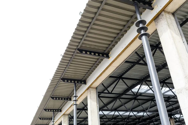Techo de aluminio con ventanas en un marco de metal. Las columnas de hierro soportan la visera. Construcción del hangar . — Foto de Stock