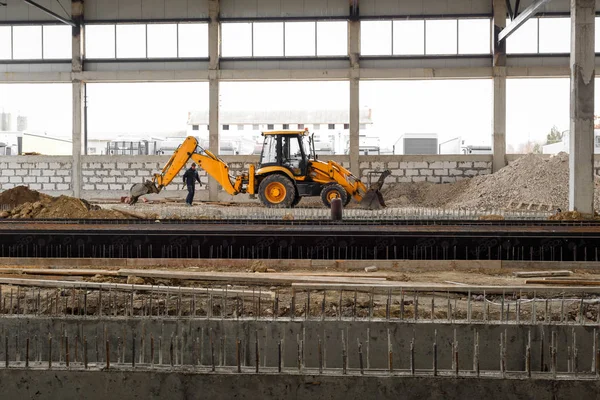 Chisinau, República de Moldavia - 04 de febrero de 2020: Excavadora y constructora en el sitio de construcción . — Foto de Stock