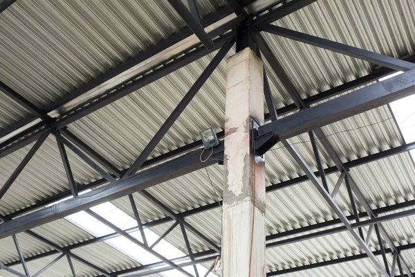 Techo de aluminio con ventanas en un marco de metal. Una columna de hormigón sostiene la estructura. Construcción del hangar . — Foto de Stock