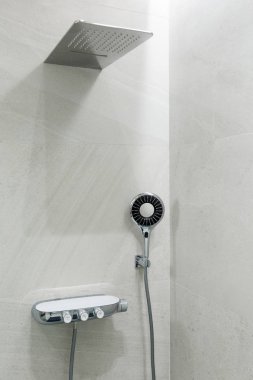 Mermer gri duvar, yağmur ve duş başlığı. Modern banyo tasarımı. Dikey çerçevelenmiş çekim.