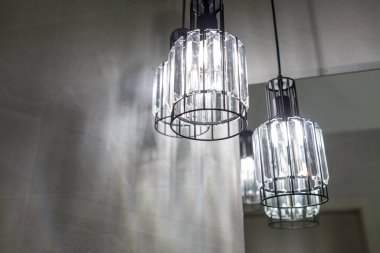 Tavan lambası. Modern üç lamba avizesi. Banyoda lamba var. Aynaya yansıyor. Yatay çerçeveli çekim.