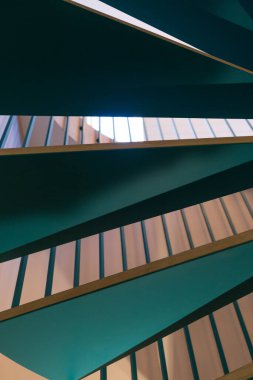 Sarmal merdivenin yeşil ahşap basamakları. Dikey çerçevelenmiş çekim.