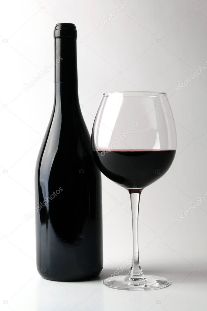 Bottle of red wine with glass