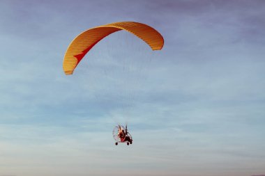 Uçuş mavi gökyüzü karşı turuncu bir kanat ile motor para plan