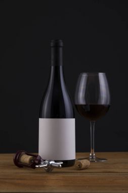 Bir siyah arka plan ve cam izole kırmızı şarap şişesi