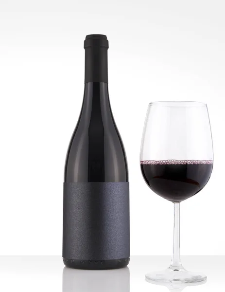 Botella aislada de vino tinto en un fondo blanco, etiqueta negra y vidrio — Foto de Stock