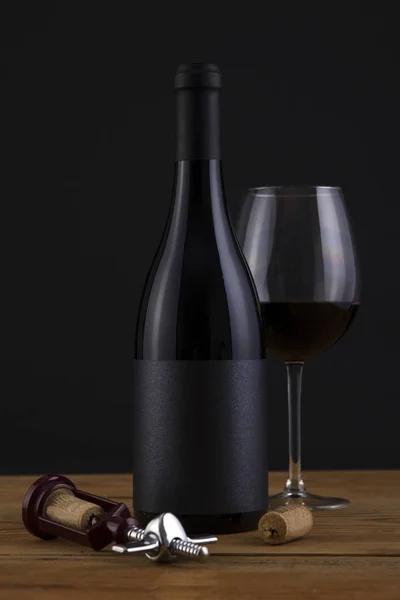 Botella aislada de vino tinto en un fondo negro y etiqueta negra — Foto de Stock