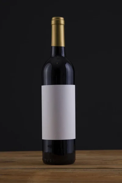 Изолированная бутылка красного вина на черном фоне — стоковое фото