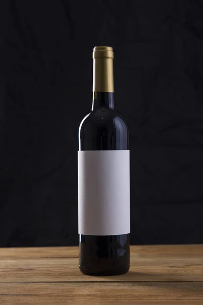 Изолированная бутылка красного вина на черном фоне — стоковое фото