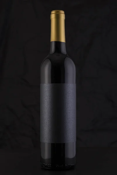 Garrafa de vinho tinto isolado em um fundo preto — Fotografia de Stock
