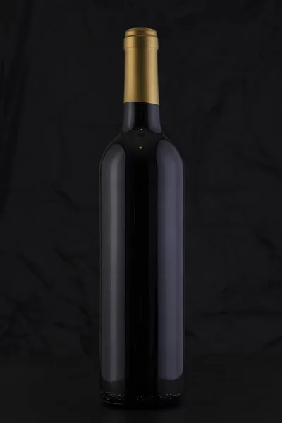 Geïsoleerde fles met rode wijn in een zwarte achtergrond — Stockfoto