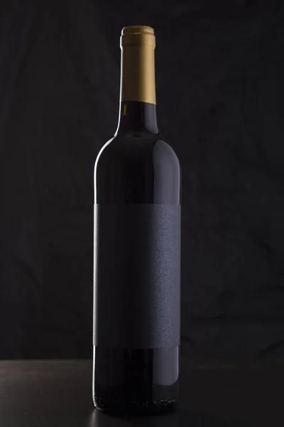 Bottiglia di vino rosso isolata in uno sfondo nero Fotografia Stock